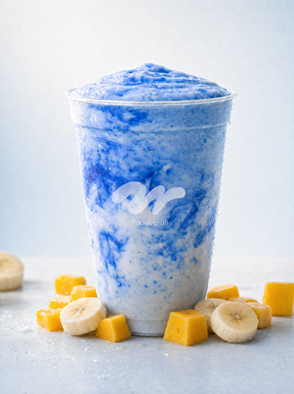 Blauer Frozen-Smoothie im immergrün-Becher mit Mango und Banane